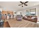 Open-concept living area and kitchen, complete with hardwood floors, comfortable seating, and a ceiling fan at 27606 W Tonopah Dr, Buckeye, AZ 85396