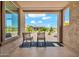 Covered back patio with rocking chairs and a view of the green backyard at 27606 W Tonopah Dr, Buckeye, AZ 85396