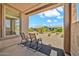 Chairs on a covered patio overlook the low-maintenance desert landscaping in the backyard at 27606 W Tonopah Dr, Buckeye, AZ 85396