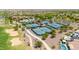Aerial view showcasing tennis courts and a lush golf course, with a swimming pool area, and desert landscaping at 27606 W Tonopah Dr, Buckeye, AZ 85396