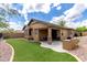 Spacious backyard featuring artificial turf, rock landscaping, and a covered patio at 29751 N 119Th Ln, Peoria, AZ 85383