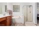 Bright bathroom features a shower, soaking tub, and neutral tile flooring at 29751 N 119Th Ln, Peoria, AZ 85383