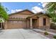 Inviting single-story home with a tan exterior, a two-car garage, and a decorative stone facade at 29751 N 119Th Ln, Peoria, AZ 85383