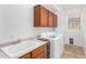 Well-lit laundry area featuring a utility sink and modern washing machine at 29751 N 119Th Ln, Peoria, AZ 85383