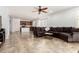 Open concept living room features a modern ceiling fan, neutral tile flooring, and plenty of natural light at 29751 N 119Th Ln, Peoria, AZ 85383