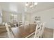 Inviting dining area featuring a modern chandelier, hardwood table, and seamless flow into the bright living space at 3067 E Merlot St, Gilbert, AZ 85298
