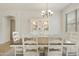 Elegant dining room showcasing a wooden table, white chairs, a decorative cabinet, and soft lighting from a chandelier at 3067 E Merlot St, Gilbert, AZ 85298