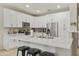 Modern kitchen boasting white cabinets, stainless steel appliances, an island with bar seating, and a bright, open layout at 3067 E Merlot St, Gilbert, AZ 85298