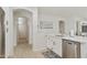 Bright kitchen featuring white cabinets, stainless steel appliances, a view of the hallway, and light wood flooring at 3067 E Merlot St, Gilbert, AZ 85298