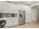 Stylish kitchen with white cabinets, stainless steel refrigerator, modern appliances, and attractive light wood flooring at 3067 E Merlot St, Gilbert, AZ 85298