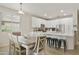Bright kitchen and dining area featuring white cabinets, stainless steel appliances, and a breakfast bar with seating at 3067 E Merlot St, Gilbert, AZ 85298