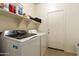 Functional laundry room equipped with modern washer and dryer units and shelving at 3067 E Merlot St, Gilbert, AZ 85298