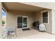 A patio with a small metal table, chairs, a BBQ grill, and a sliding door leading indoors at 3067 E Merlot St, Gilbert, AZ 85298
