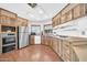 Cozy kitchen equipped with stainless steel appliances, wooden cabinets, and a bright window over the sink at 3433 E Sandra Ter, Phoenix, AZ 85032
