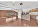 Open floor plan with hardwood floors, ceiling beams, and a view of the kitchen featuring wooden cabinets at 3433 E Sandra Ter, Phoenix, AZ 85032