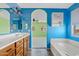 Bright bathroom with blue walls showcasing a vanity with sink, tub, and views of the bedroom at 3623 E Horace Dr, Gilbert, AZ 85296