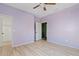 Bedroom with light purple walls, wood-look floors, ceiling fan, and a view into the closet at 3623 E Horace Dr, Gilbert, AZ 85296