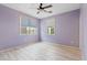 Bedroom showcasing light purple walls, wood-look floors, a ceiling fan, and natural light through windows at 3623 E Horace Dr, Gilbert, AZ 85296