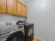 Functional laundry room featuring a modern washer and dryer set with overhead cabinet storage at 3623 E Horace Dr, Gilbert, AZ 85296