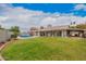 Expansive backyard with a lush lawn, a sparkling pool, covered patio and barbecue area for outdoor living at 3701 E Morrow Dr, Phoenix, AZ 85050
