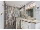Modern bathroom featuring a tiled shower, granite countertop vanity, and decorative mirror and lighting at 3701 E Morrow Dr, Phoenix, AZ 85050