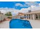 Backyard oasis featuring a private swimming pool with an umbrella and rock landscaping on a sunny day at 3701 E Morrow Dr, Phoenix, AZ 85050