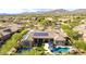 Aerial view of a house featuring a pool with umbrellas and a basketball court and mountain views at 37301 N 99Th St, Scottsdale, AZ 85262