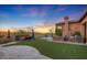 Manicured backyard with outdoor kitchen, pizza oven, BBQ, turf, and sports court at 37301 N 99Th St, Scottsdale, AZ 85262
