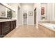 Elegant bathroom with dark wood cabinets, soaking tub, and a tiled shower at 37301 N 99Th St, Scottsdale, AZ 85262