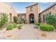 Inviting home entrance with desert landscaping, a paved walkway, and a charming arched doorway at 37301 N 99Th St, Scottsdale, AZ 85262