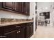 Elegant kitchen featuring granite countertops, dark wood cabinets, and stainless steel appliances at 37301 N 99Th St, Scottsdale, AZ 85262