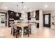 Modern kitchen featuring an island with seating, stainless steel appliances, and dark wood cabinets at 37301 N 99Th St, Scottsdale, AZ 85262