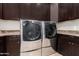 This laundry room has modern appliances and dark cabinetry at 37301 N 99Th St, Scottsdale, AZ 85262