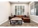 Bright living room with a comfortable leather sectional, wood floors, and plantation shutters at 37301 N 99Th St, Scottsdale, AZ 85262