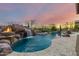 Backyard pool with rock waterfall feature, spa, and fire bowls creating a luxurious outdoor space at 37301 N 99Th St, Scottsdale, AZ 85262