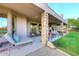 A comfortable back porch with stone columns, outdoor seating, and a view of the lawn at 39241 N Boulder View Dr, Scottsdale, AZ 85262