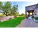 A well-manicured backyard with a covered porch and a lush green lawn at 39241 N Boulder View Dr, Scottsdale, AZ 85262