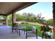 Scenic backyard retreat featuring a covered patio, lush lawn, and picturesque desert landscape at 39241 N Boulder View Dr, Scottsdale, AZ 85262