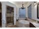 Elegant bathroom with a soaking tub, glass block window, and a tiled walk-in shower at 39241 N Boulder View Dr, Scottsdale, AZ 85262