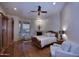 Spacious bedroom with a decorative fireplace, sitting area, wood floors, ceiling fan and large windows at 39241 N Boulder View Dr, Scottsdale, AZ 85262
