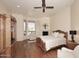 Spacious bedroom with hardwood floors, bay window, fireplace, ceiling fan, and wooden furnishings at 39241 N Boulder View Dr, Scottsdale, AZ 85262