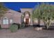Close-up showcasing the home's entrance with arched portico, solid wood double doors, and stone pathway at 39241 N Boulder View Dr, Scottsdale, AZ 85262