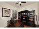 Cozy office space with a large desk, dark bookcase, and a ceiling fan at 39241 N Boulder View Dr, Scottsdale, AZ 85262