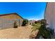 Gravel backyard with mature trees and a block wall fence at 4080 W Goldmine Mountain Dr, San Tan Valley, AZ 85144