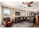 Comfortable living room featuring a ceiling fan, an area rug, and an open view to the kitchen area at 4080 W Goldmine Mountain Dr, San Tan Valley, AZ 85144