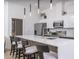 Stylish kitchen featuring a quartz countertop island with bar seating, stainless steel appliances, and modern pendant lighting at 4220 N 32Nd St # 31, Phoenix, AZ 85018