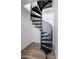 Modern home interior showcasing a black spiral staircase with light hardwood floors and white walls at 4220 N 32Nd St # 31, Phoenix, AZ 85018