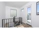Bright staircase landing with modern railing, white walls, and a door leading to outdoor space at 4220 N 32Nd St # 31, Phoenix, AZ 85018