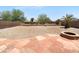 Large backyard featuring gravel landscaping, a fire pit, and a desert palm tree at 43530 W Eddie Way, Maricopa, AZ 85138