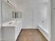 Bathroom featuring double vanity, tub, tiled floor, and neutral color palette at 43530 W Eddie Way, Maricopa, AZ 85138